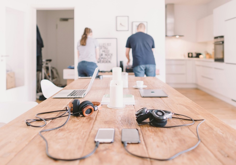 couple working with orange and black headphones on table