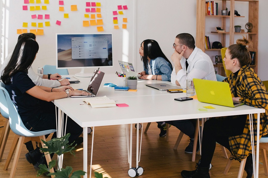 five person by table watching turned on white imac photo