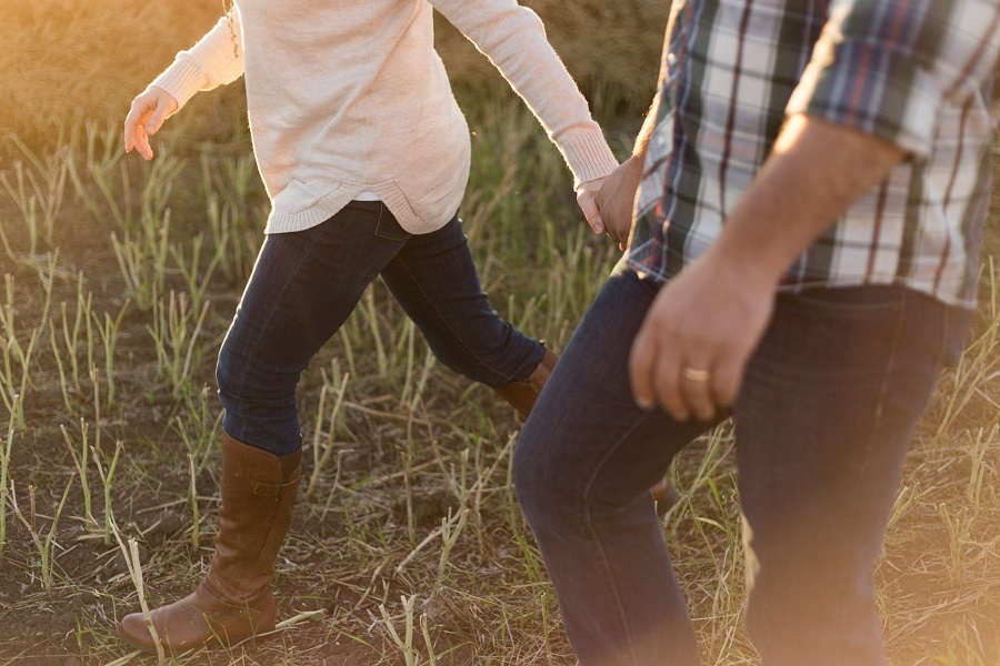 two person wearing denim pants on grass field