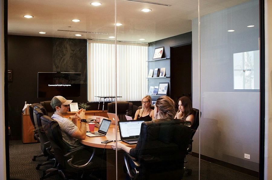 people sitting near table with laptop computer at work