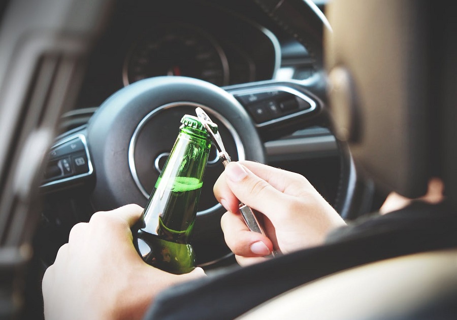 Person Opening a Bottle While Driving a Car